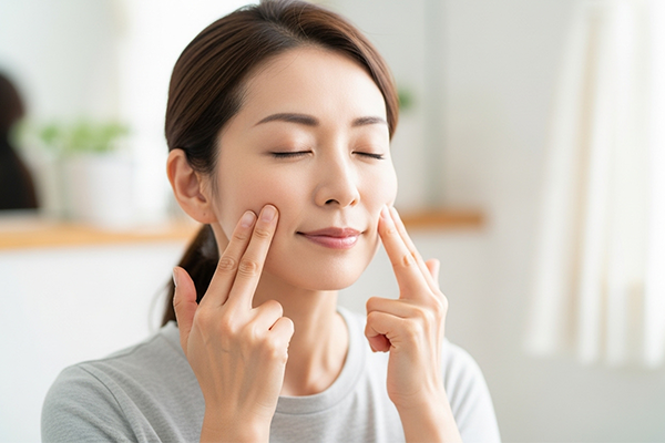 顔のマッサージする女性